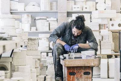 Craftsman using pottery wheel while working in art studio