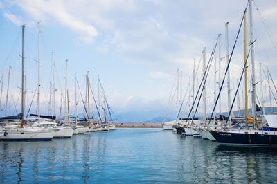Sailboats moored on sea against sky