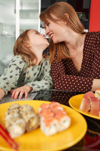 Side view of young woman having food at restaurant