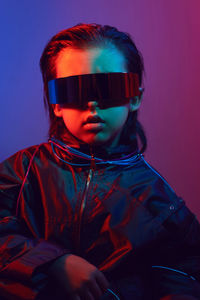 Portrait cyberpunk boy child in vr glasses in blue and red tones. game, virtual reality
