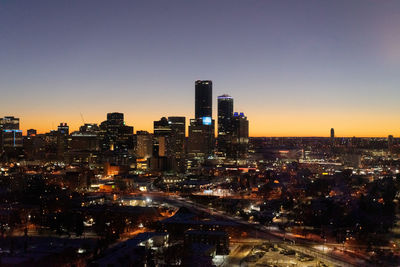 Illuminated city against sky during sunset