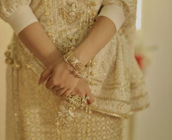 Midsection of bride holding wedding dress