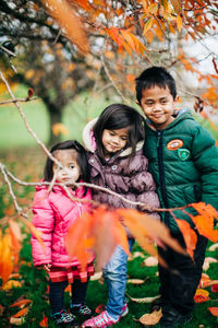 Portrait of smiling girl standing outdoors during autumn