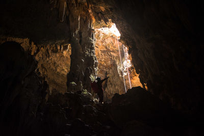 People standing on rock in cave