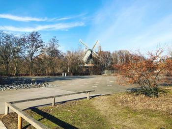 Scenic view of park by lake against sky