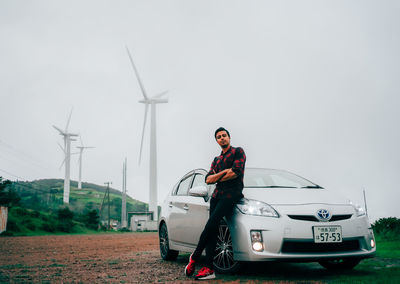 Man on car against sky