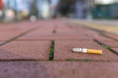 Close-up of cigarette on footpath