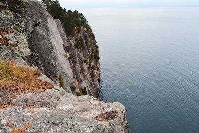 Rock formations by sea against sky