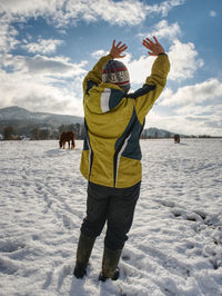 Farmer woman shout to horses in snowy pasture. winter day. mountain horses farm stuff works each day