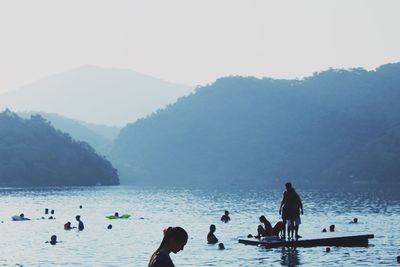 Silhouette of people surfing in sea