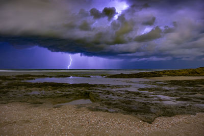 Scenic view of sea against storm clouds