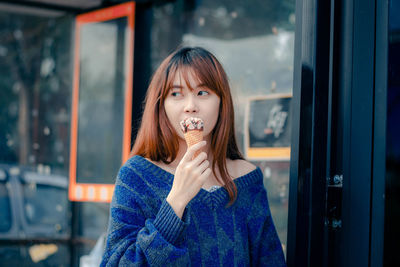 Portrait of young woman standing outdoors