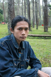 Portrait of young woman sitting in park