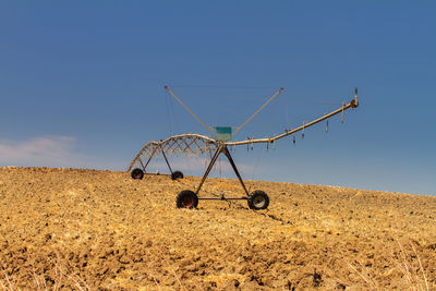 Ferris wheel on field against clear sky