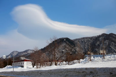 Scenic view of snow covered mountains against cloudy sky