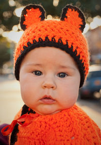 Cute baby is wearing a unique costume grandma made out of colorful yarn