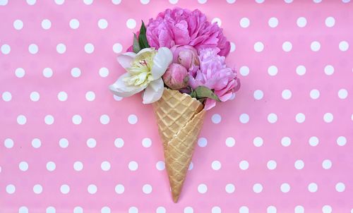 Directly above shot of peony flowers with ice cream cone on table