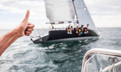 Close-up of hand on boat sailing in sea