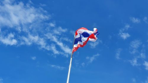 Low angle view of flag against blue sky