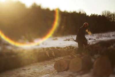 Full length of lumberjack working in forest on sunny day