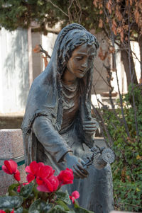 Statue of buddha against plants at cemetery