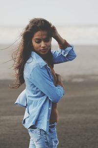 Side view of young woman standing at beach