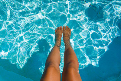 Low section of person legs in swimming pool