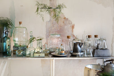 Empty chairs and table with glassware against wall at home