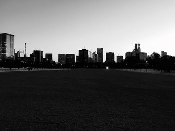 Silhouette buildings in city against clear sky