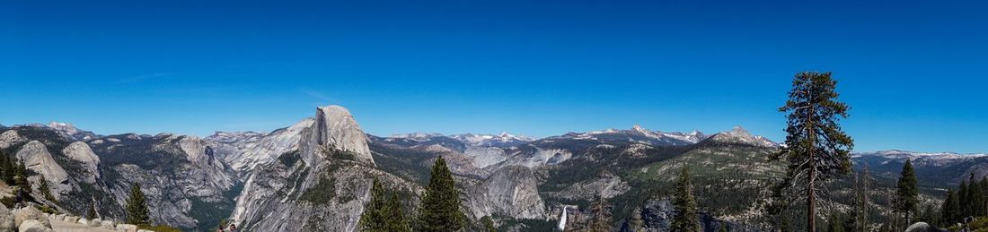 Panoramic view of mountain range against blue sky