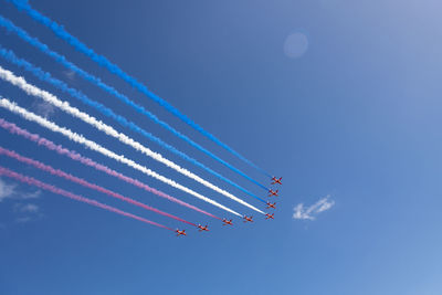 Low angle view of airplane flying against blue sky