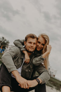 Portrait of smiling friends sitting at beach