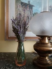 Close-up of flower vase on table by window at home