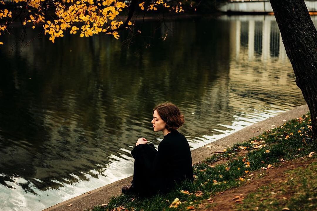 SIDE VIEW OF A WOMAN SITTING IN LAKE