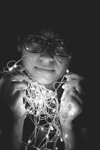 Close-up of girl holding eyeglasses against black background