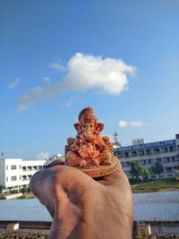 Midsection of man statue against building against sky