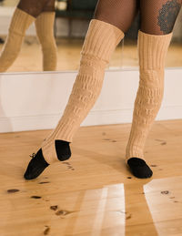 Low section of woman standing on hardwood floor