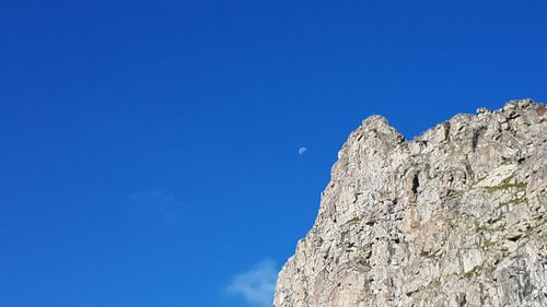 Low angle view of rock formation against clear blue sky