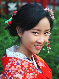 Portrait of smiling girl with red flower