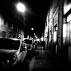 Cars on illuminated road in city at night