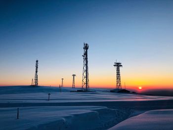 Silhouette of power transmission towers at sunset in winter