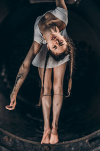 Full length of young woman standing against water