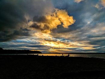 Scenic view of beach against cloudy sky