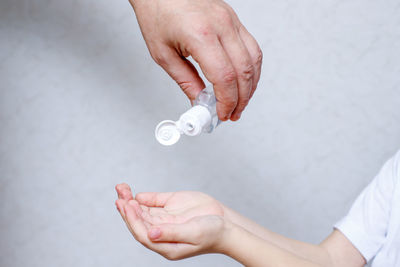 Close-up of man holding hands over white background