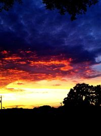 Silhouette landscape against dramatic sky during sunset