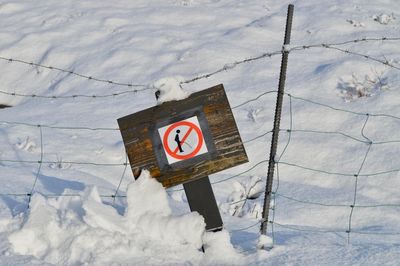 High angle view of road sign on snow covered land