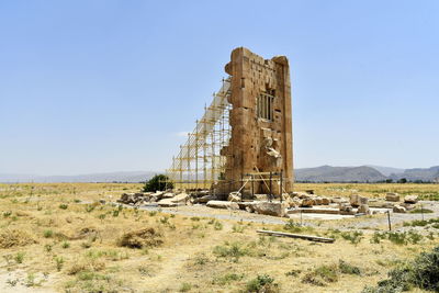 Old ruin on field against clear blue sky