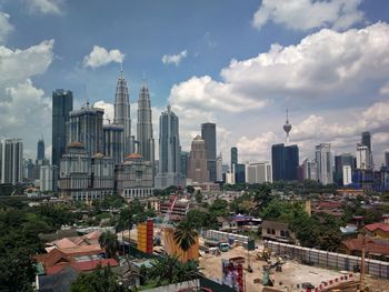 Buildings in city against cloudy sky