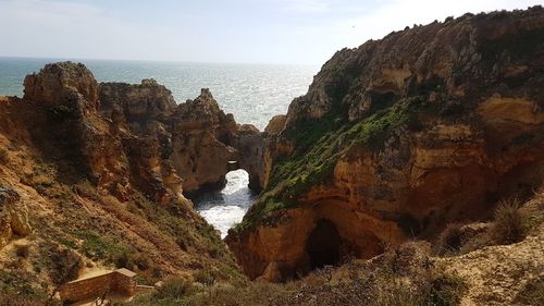 Rock formations by sea against sky