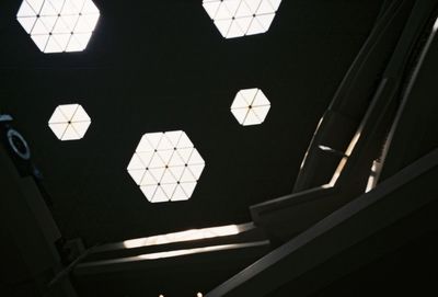 Low angle view of illuminated lights hanging on ceiling in building